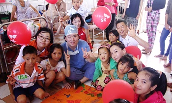 베트남 어린이들이 SK 자원봉사단, SK 대학생 봉사단 써니 등과 수술 성공을 기원하는 승리의 V표를 함께 하고 있다(사진 SK그룹 제공)
