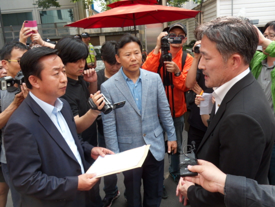 정익훈 새누리당 민원국장(왼쪽)에게 청원서를 전달하고 있는 표창원 전 경찰대 교수(오른쪽)