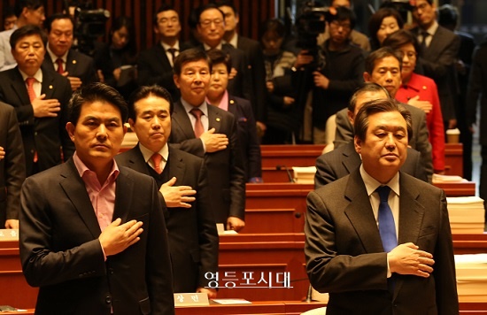 김무성 대표는 1월 29일 열린 새누리당 의원총회의 국민의례에서 국기에 대한 경례를 하고 있다. [사진 안현준 기자]