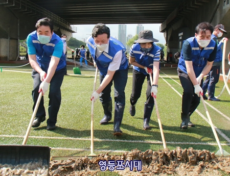 김영주 국회의원(사진 오른쪽에서 두 번째)과 채현일 구청장 (왼쪽에서 두 번째)가 밀대를 밀며 펄 제거 작업을 하고 있다. Ⓒ영등포시대 