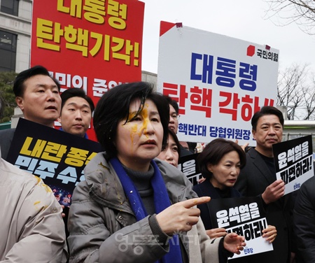 ▲백혜련 더불어민주당 의원이 20일 서울 종로구 헌법재판소 앞에서 열린 윤석열 대통령 신속 파면 촉구 기자회견 중 한 보수단체 회원이 던진 계란에 얼굴을 맞은 뒤 항의하고 있다. ©백혜련 의원 페이스북