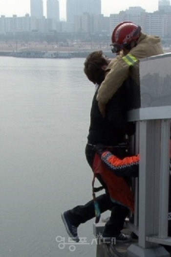 ▲서울의 한 교량에서 자살을 시도 하던 한 시민이 소방대원으로부터 구조되고 있다./이미지=영등포시대 db