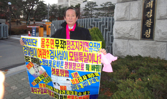 24일 대검찰청 앞에서 한상대 검찰총장 퇴진을 요구하고 있는 활빈단 홍정식 대표. 그가 들고 있는 '몸주면 무죄? 정조키면 유죄'라는 문구가 눈에 띈다.     &copy; 활빈단 제공 