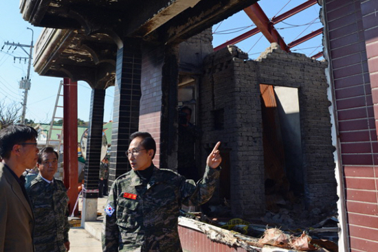 지난 10월 18일 서해 최북단 연평도 연평부대를 방문한 이명박 대통령이 2010년 북한의 연평도 포격 당시 파괴된 건물을 살펴보고 있다.     ⓒ 청와대 공동취재단