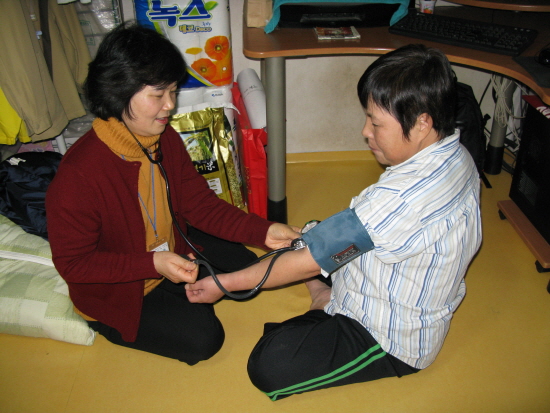 보건소 방문 간호사가 독거노인 가구를 방문해, 혈압 등 건강을 체크하고 있다