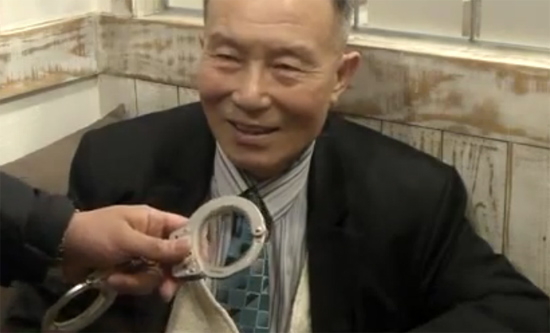 ▲ 21일 오후 6시 28분 경 서울 모처에서 인터뷰를 진행하고 있던 조웅 목사에 대해 서울중앙지검 검찰 수사관들이 체포영장을 제시하는 가운데 수갑을 채워 연행하기 위해 수갑을 내밀고 있다. ⓒ아프리카TV 해당 동영상 이미지 캡쳐