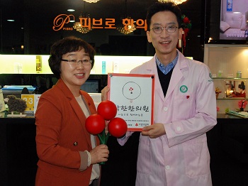 서울 사회복지공동모금회 팀장(왼쪽)이 오충선 서초 피브로한의원장(오른쪽)에게 착한가게현판을 전달하고 있다. 