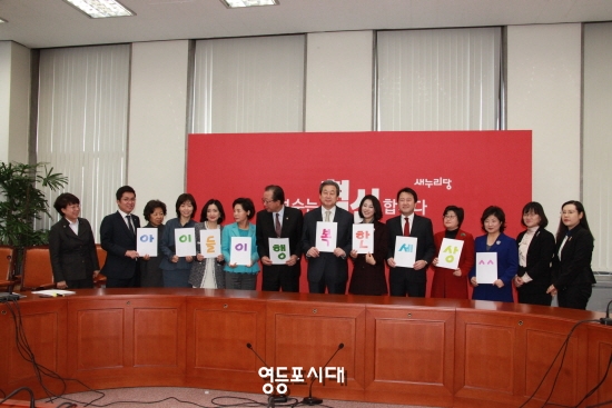 김무성 대표최고위원(사진 오른쪽에서 일곱 번째)이 아동학대근절특위 위원들에게 임명장을 수여한 후 손 피켓을 들고 기념촬영을 하고 있다. &copy;안영혁 기자