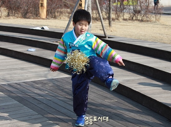 하나, 둘, 셋 한복을 곱게 차려입고 부모와 함께 경복궁을 찾은 아동이 제기차기를 하고 있다. 