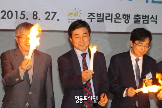  ‘주빌리은행’ 출범식에 참석한 이종걸 새정치민주연합 원내대표(사진 가운데)와 유종일 교수(사진 오른쪽)가 불꽃 퍼포먼스를 펼치고 있다. ⓒ영등포시대