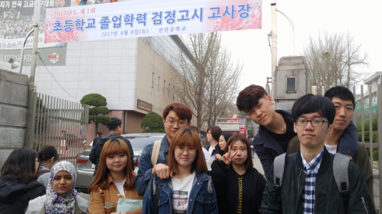 서울온드림교육센터 중도입국 청소년이 검정고시 시험장 앞에서 기념촬영을 하고 있다. 