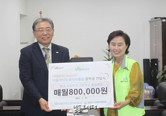 김재원 국제로타리 3640지구 서울여의도로타리클럽 회장(사진 왼쪽)이 7월 31일 오전 서울 신금자 영등포구 사회복지협의회 사무국장에게 장학금 증서를 전달하고 있다. &copy;영등포시대 