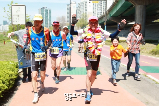80세 고령에도 불구하고 공인마라톤 대회에서 500회 완주를 성공한 장재연 어르신(사진 오른쪽)이 두 손을 번쩍 들어 보이고 있다. Ⓒ영등포시대  