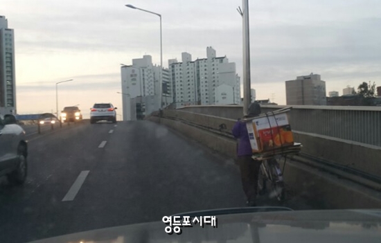12일 아침 한 어르신이 폐지를 자전거에 싣고 도림고가를 넘어가고 있다.&copy;영등포시대.