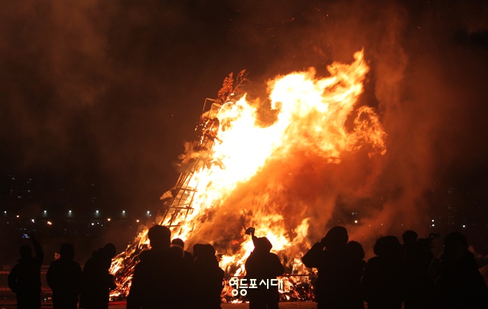 활활 타고 있는 달집을 바라보며 주민들이 한해의 안녕을 빌고 있다. Ⓒ영등포시대