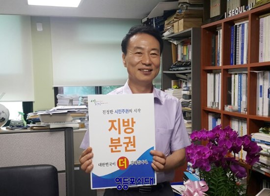  김정태 ‘제10대 서울시의회 지방분권TF’ 2기 단장이 8월 20일 오후 서울시의회 의원회관에서 손팻말을 들고 포즈를 취하고 있다. Ⓒ영등포시대 