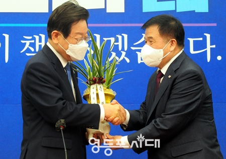 ▲이재명 대표가 30일 국회를 방문한 대통령실 이진복 정무수석으로부터 윤석열 대통령의 축화 화분을 건네받고 있다. Ⓒ영등포시대 