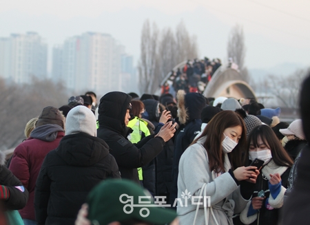 ▲선유교를 찾은 시민들이 휴대전화기로 떠오르는 태양을 찍고 있다. ⓒ영등포시대