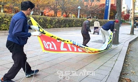 ▲불법 현수막을 철거하고 있는 동 주민센터 직원들