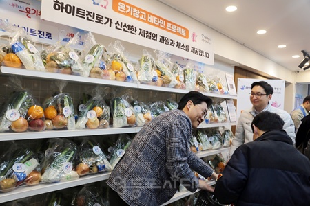 ▲(주)하이트진로 관계자가 쪽방주민에게 비타민 꾸러미를 건네고 있다. ⓒ서울시 제공