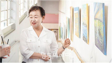 ▲시각장애인 한영희 작가가 영등포장애인복지관 내 경사로에서 열린 개인전 ‘마음으로 본 세상, 빛으로 남긴 순간’ 전시회에서 작품을 설명하고 있다. ©서울시영등포장애인복지관 제공